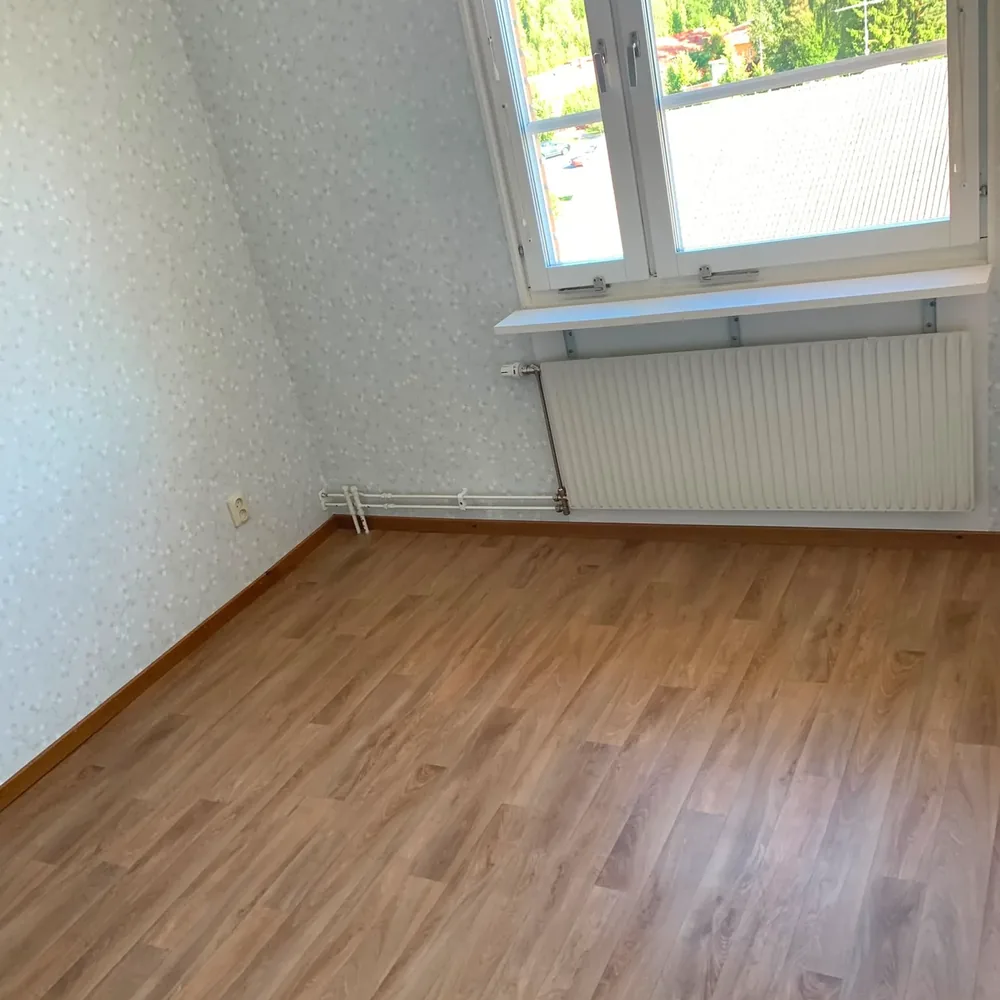 Nystädat rum med rent laminatgolv efter flyttstädning